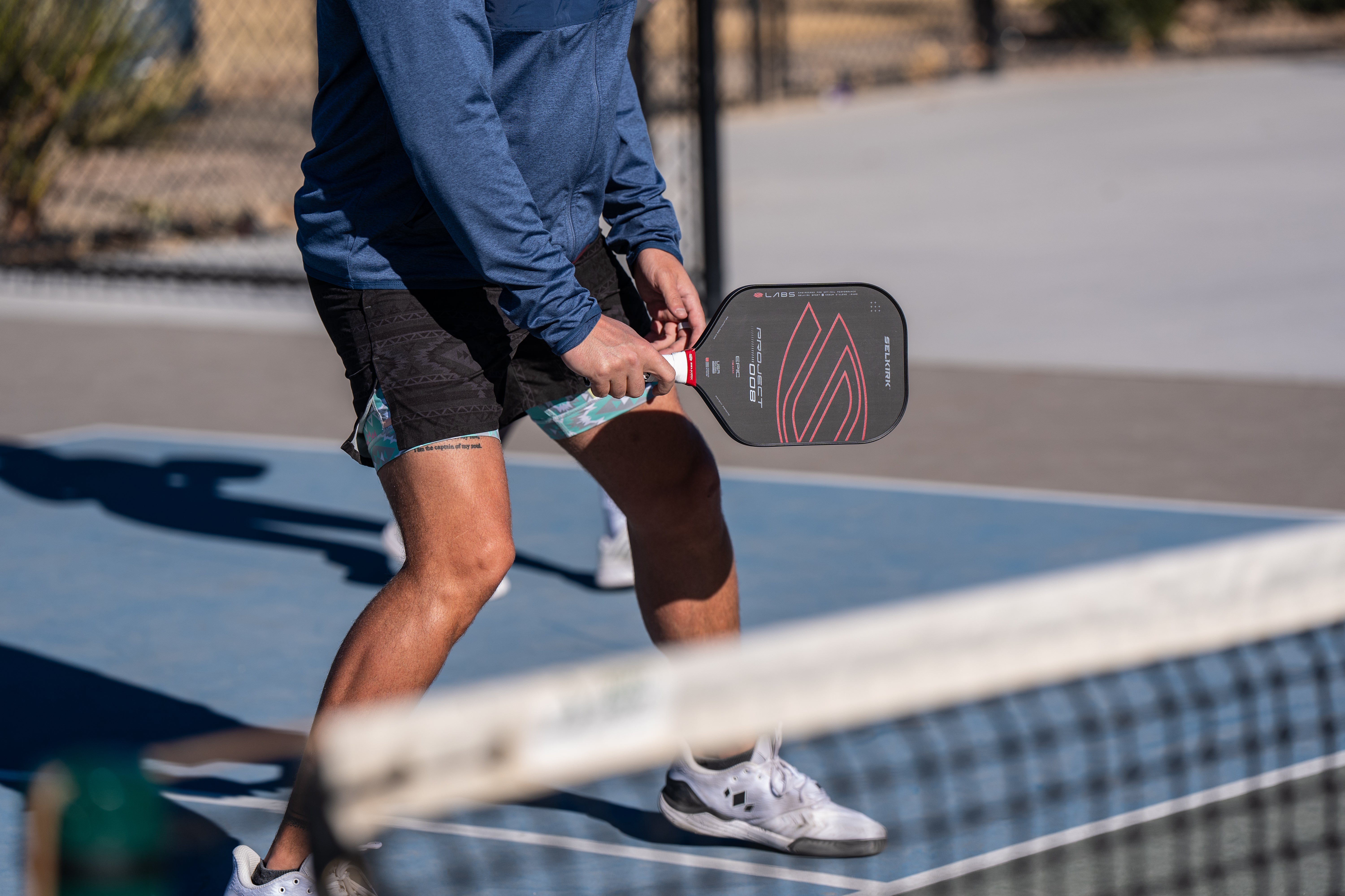 A man prepares to receive a volley shot with his Selkirk LABS 008 paddle. 