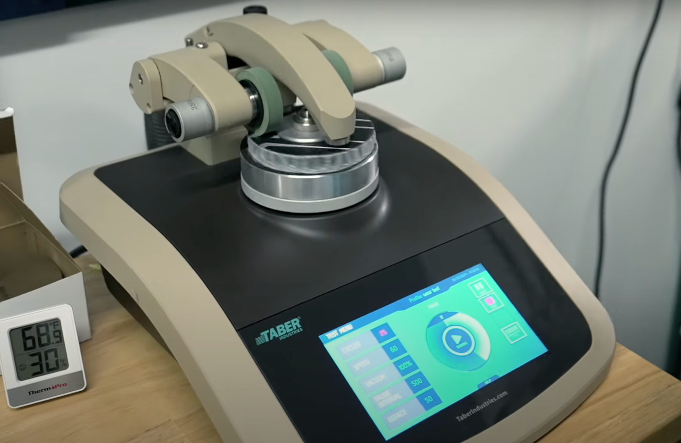 A Taber Abrasion Testing machine rotates two materials against each other to test their durability. 
